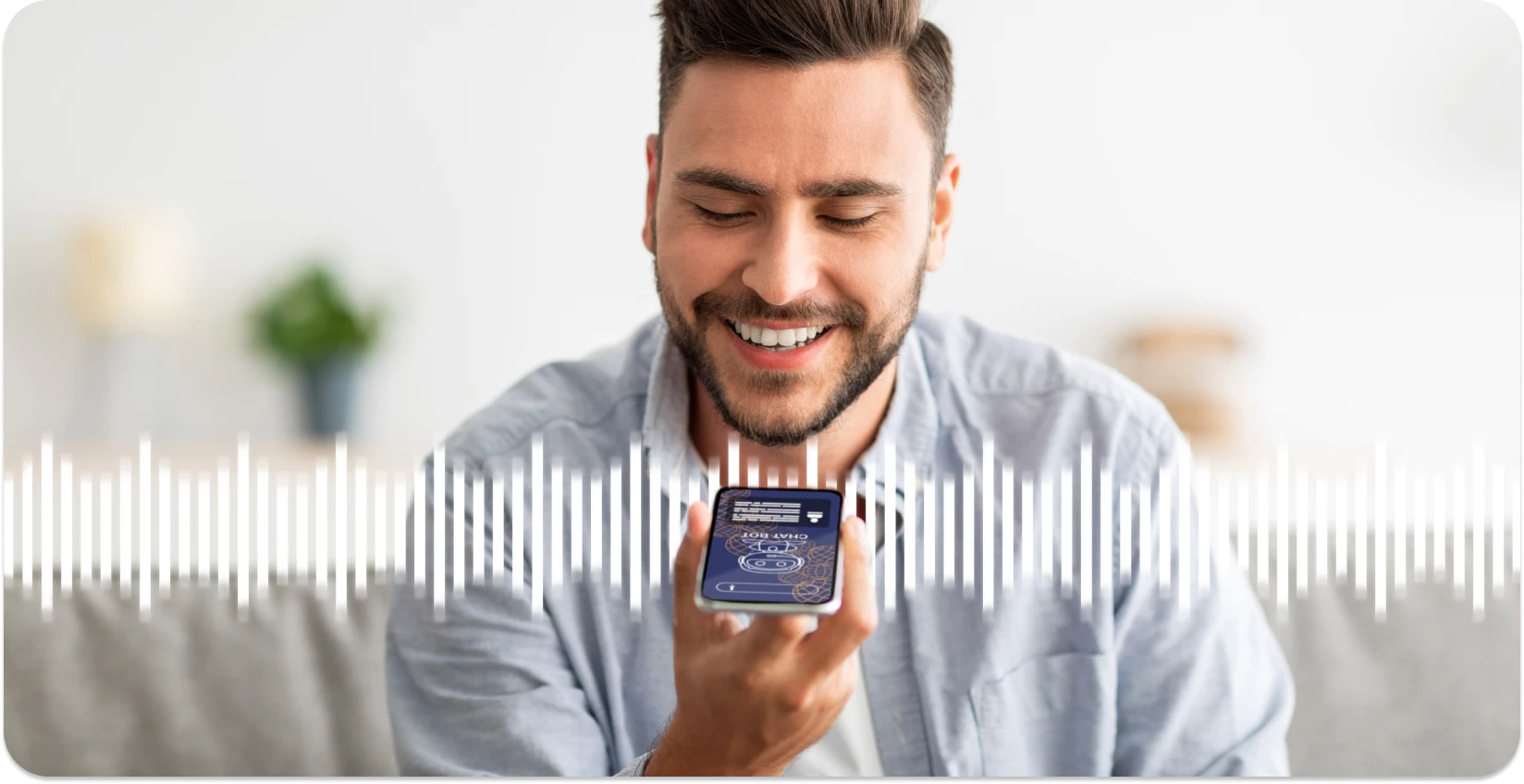 رجل يبتسم أثناء استخدام تطبيق الهاتف الذكي لقص الموجات الصوتية ، وتعزيز تجربة التحرير عبر الإنترنت.