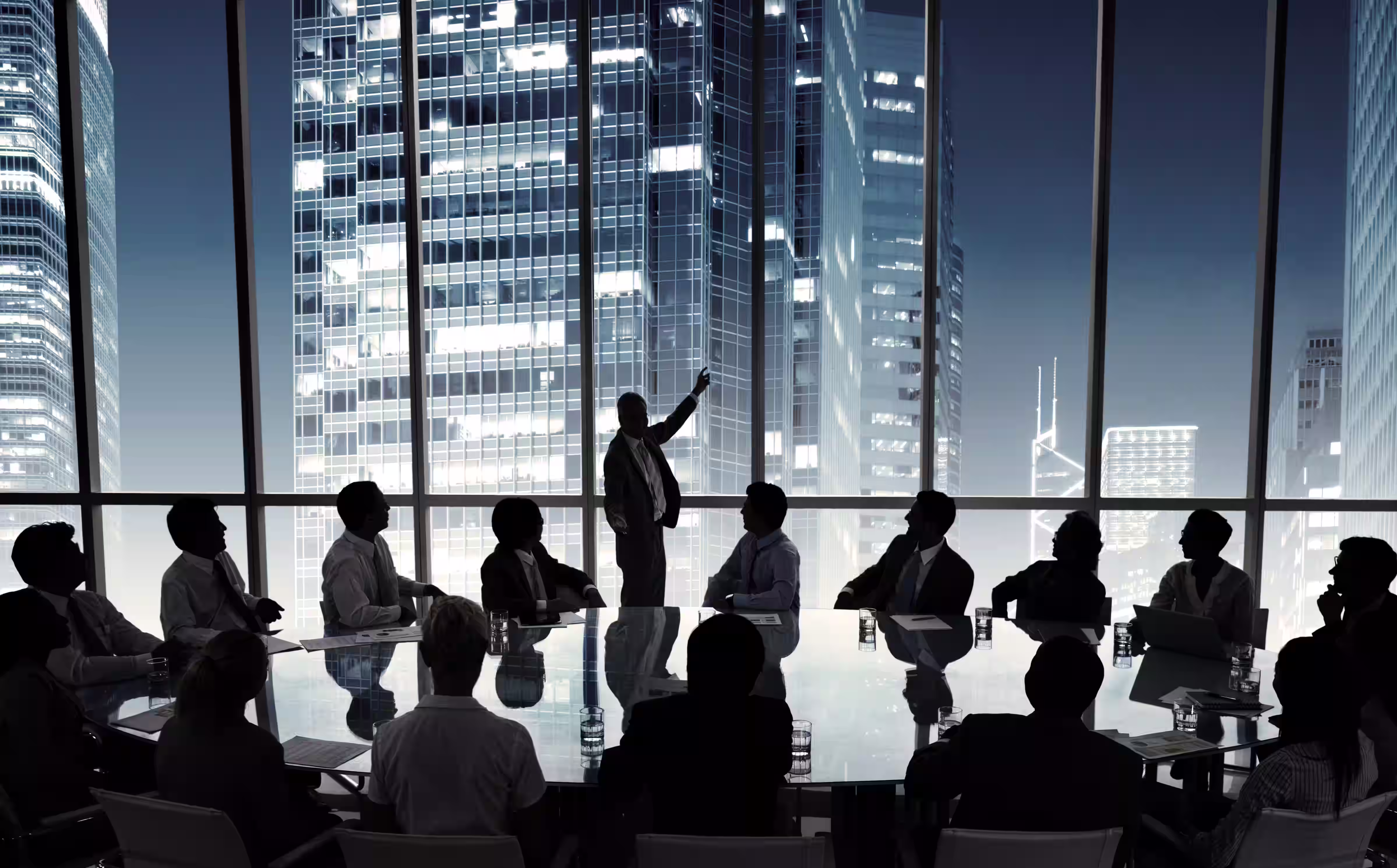 Silhouette of business professionals in a conference room with city skyline view