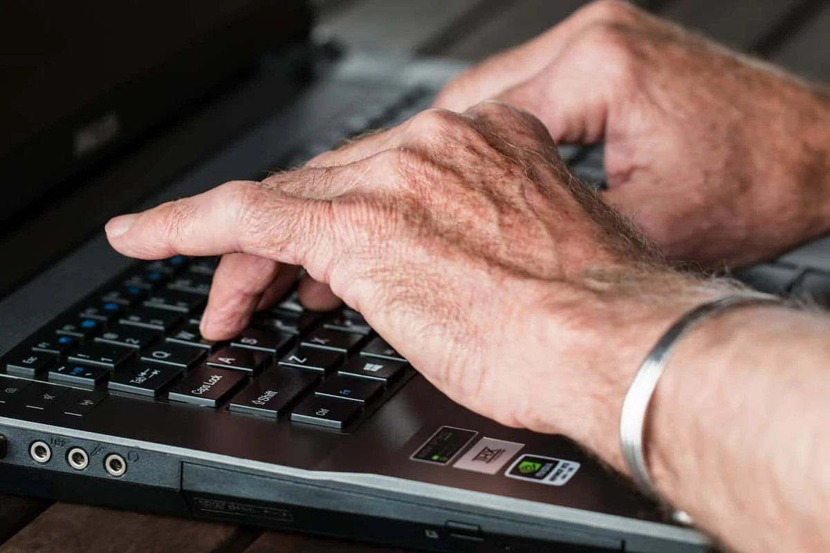 an old guy typing on his computer