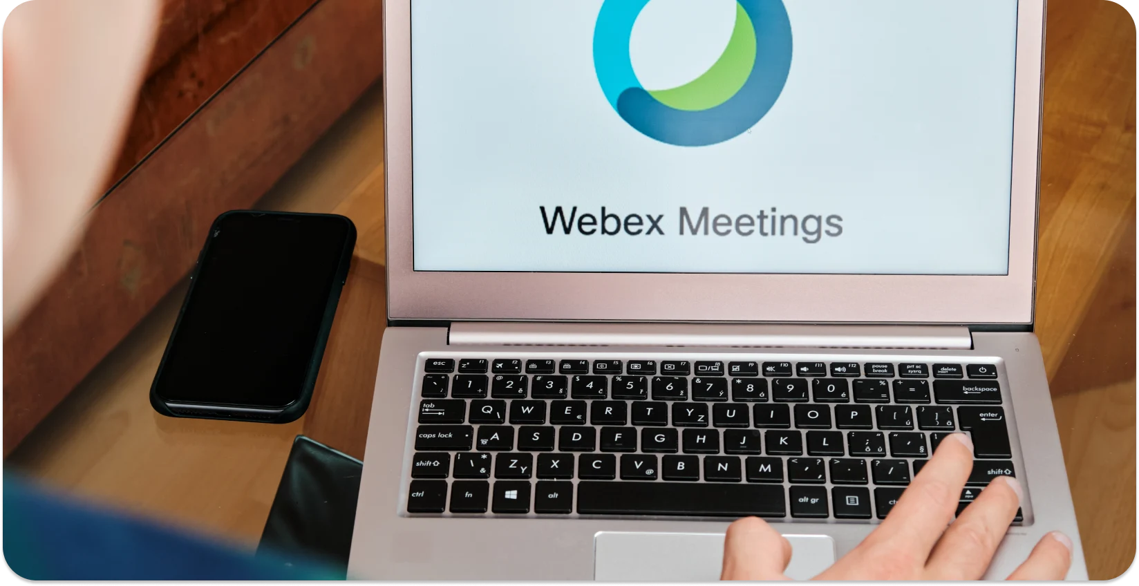 En person som starter et Webex møte på en bærbar datamaskin, klar for automatisk transkripsjon.